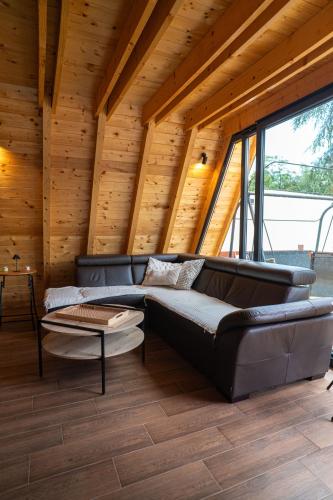 ein Wohnzimmer mit Ledersofa und einem Tisch in der Unterkunft Vila Markizo in Barajevo