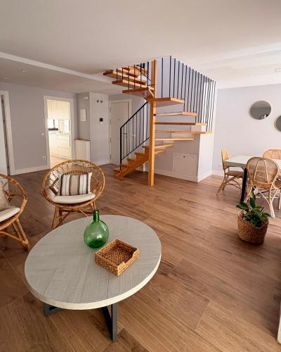 a living room with a table and a spiral staircase at Canto de la Perdiz in Villafranca del Bierzo