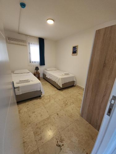 a room with two beds and a window at Ilya Apart 1 in Bodrum City