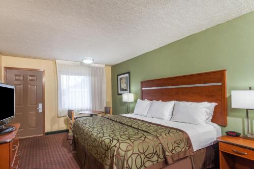 a hotel room with a bed and a television at Baymont by Wyndham Pigeon Forge near Island Drive in Pigeon Forge