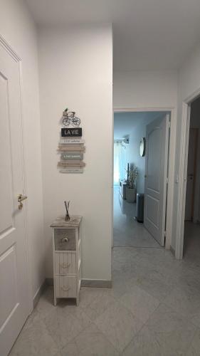 a hallway with a table and a sign on a wall at Victoria Palace T2 de 50m2 in Menton