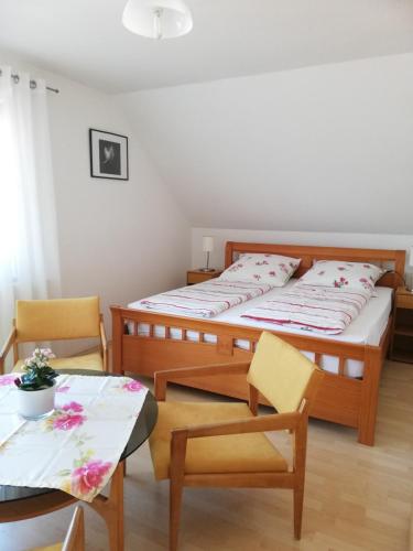 a bedroom with a bed and a table and chairs at Ferienwohnung am Bodensee mit 3 Schlafzimmer über 2 Etage mit kleine Balkon bis 6 Personen in Überlingen