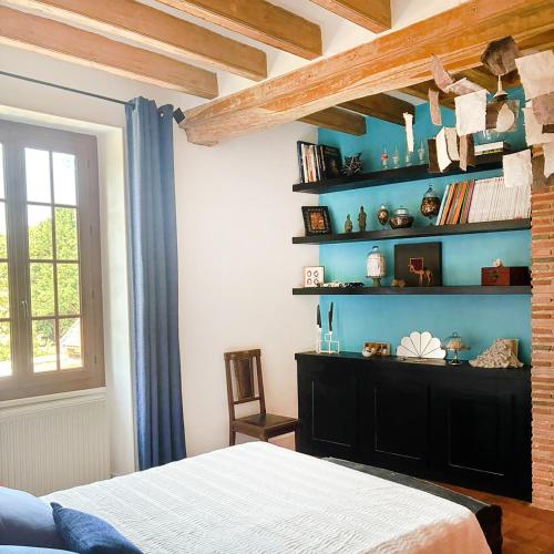 a bedroom with a bed and a blue wall at La savignacoise in Savigny-en-Sancerre
