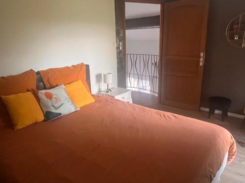 a bedroom with a bed with orange sheets and yellow pillows at Villa LA BELLE ETOILE in Étoile-sur-Rhône