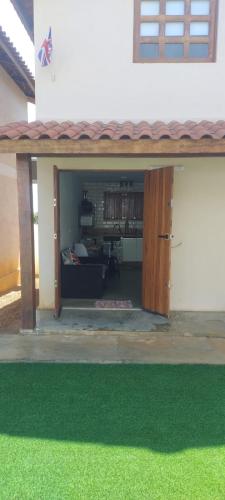 an open garage with green grass in front of a house at Chalés Jacumã Paradise in Jacumã