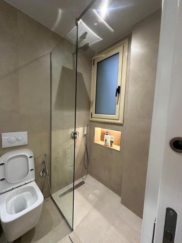 a bathroom with a toilet and a glass shower at Ionian Rooms in Vlorë