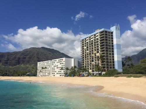 a building on the beach next to the ocean at Oceanfront Corner Unit , Hawaiian Princess in Waianae