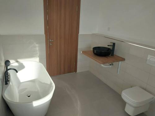 a white bathroom with a sink and a toilet at Shiri Beach Resort in Zanzibar City
