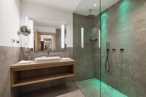 a bathroom with a sink and a glass shower at Hotel Greifenstein in Terlano