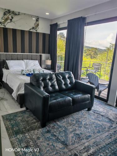 a bedroom with a bed and a leather couch at La Parada House 25 in Concepción