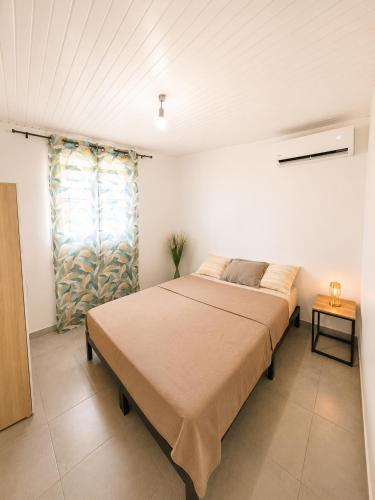 a bedroom with a large bed in a room at Les Cocons des Alizés in Sainte-Anne