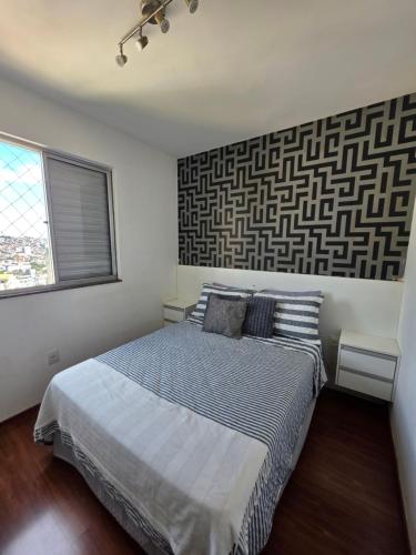 a bedroom with a large bed and a wall at Apartamento 2 Quartos Moderno in Belo Horizonte