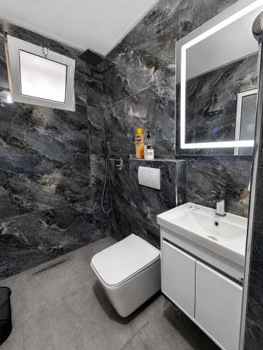 a bathroom with a white toilet and a sink at Thethi Paradise Hotel & Restaurant in Theth