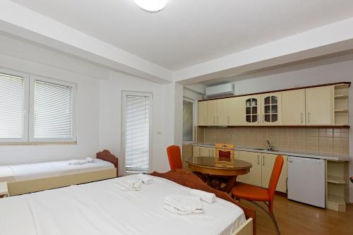 a room with two beds and a table and a kitchen at Nikola Apartments in Ohrid