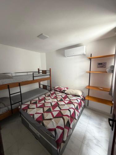 a bedroom with a bed and two bunk beds at Flat do Lucca 02 - Piscina - 50m da Praia - Até 10 Pessoas in Tamandaré