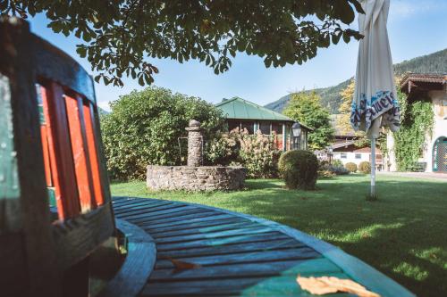 a table with an umbrella in a yard with a house at Hotel Senningerbräu in Bramberg am Wildkogel