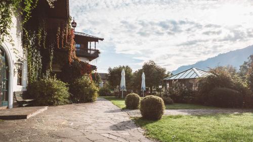 a house with a patio and a yard with umbrellas at Hotel Senningerbräu in Bramberg am Wildkogel