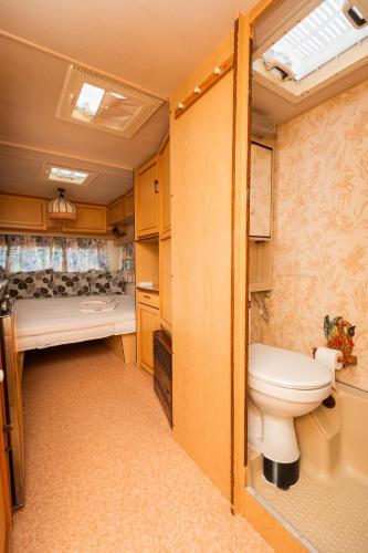 a bathroom with a toilet and a bed in a room at Camping Little Oasis in Ezerets