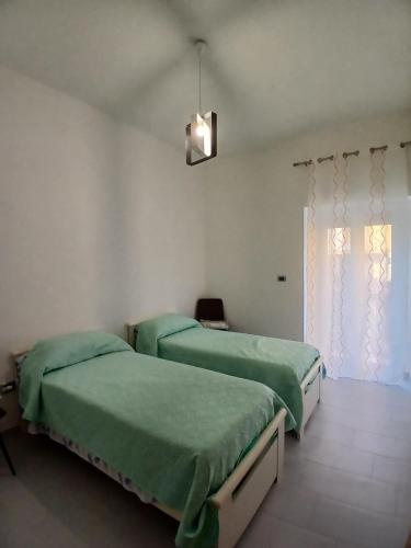 a bedroom with two beds and a window at Victoria Home in Eboli