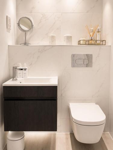 a white bathroom with a sink and a toilet at Luxury Central Solihull Apt - King Bed, Sofa Bed & 2 Parking Spaces in Solihull