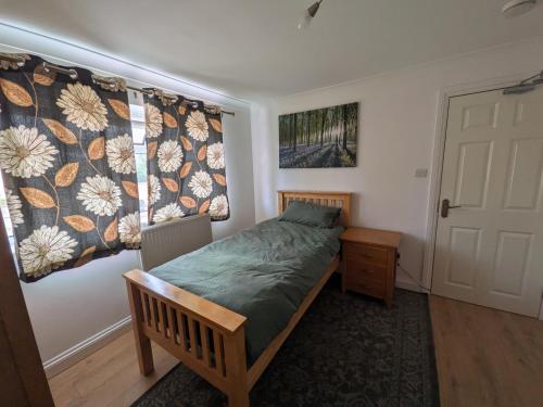 a small bedroom with a bed and a window at 6 bedroom house Trochetia in Crawley