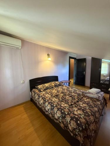 a bedroom with a bed with a floral bedspread at Home in Mtskheta in Mtskheta