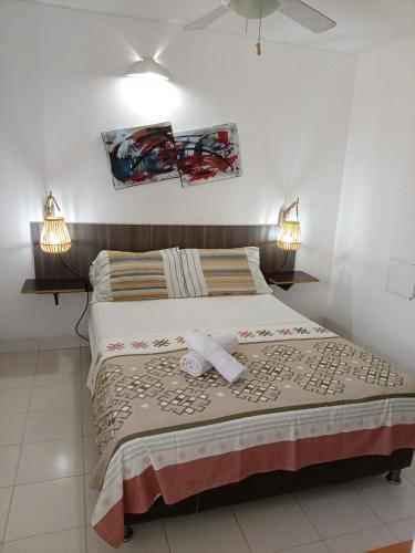 a bedroom with a bed with two towels on it at Lindo en el rodadero in Gaira