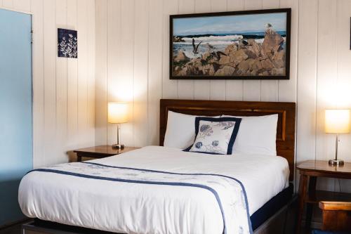 a bedroom with a bed with two lamps and a picture on the wall at Tillicum Beach Motel - Formerly Deane's Oceanfront Lodge in Yachats