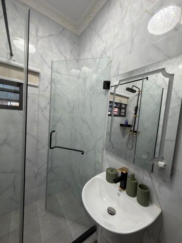 a white bathroom with a shower and a sink at Bellagio Two Bedroom with Balcony in Kwedonu