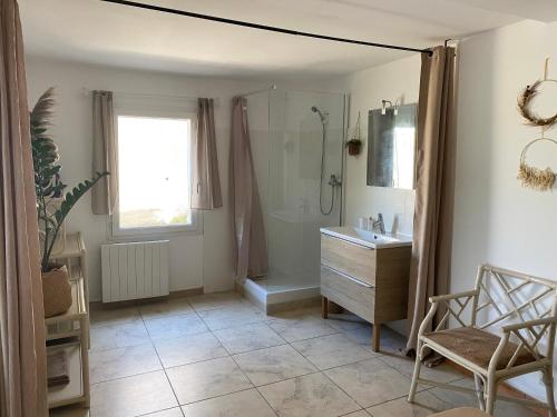 a bathroom with a shower and a sink and a mirror at Le Cocon de Réals in Murviel