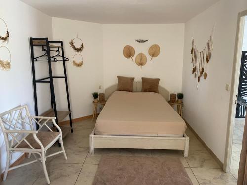 a bedroom with a bed and a chair at Le Cocon de Réals in Murviel