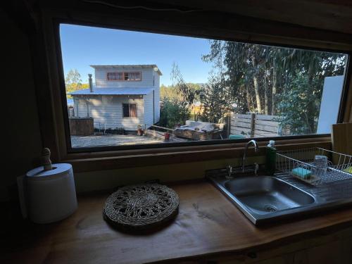 a kitchen counter with a sink and a large window at Cabaña en Buchupureo in Tiuquilemu