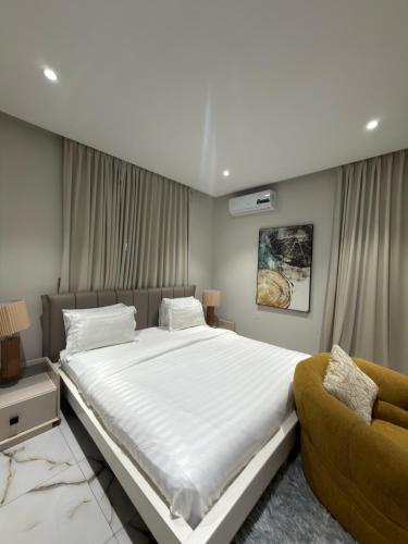 a bedroom with a large bed and a couch at Bellagio Two Bedroom with Balcony in Kwedonu