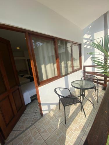 a balcony with a table and chairs and a bed at Costa Beach in Zorritos