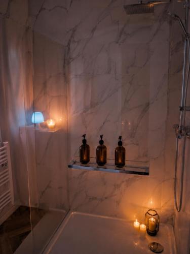 a bathroom with candles on a shelf in a shower at BLOM Spa privatif près de Douai, salle de massage, petit-déjeuner inclus in Guesnain