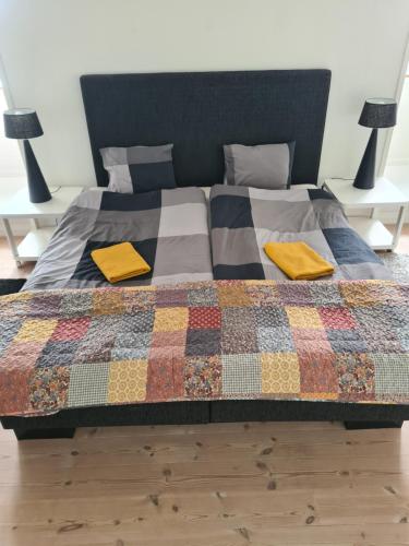 a bed with two yellow pillows on top of it at Exclusive boende Suite 2 med 4 bäddar i stort sovrum varav 2 bäddar kan stänga om sig in Frederikshavn