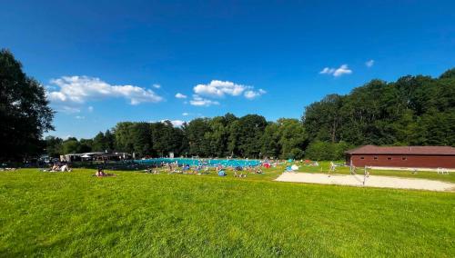 a group of people laying on the grass in a field at Maringotka Rozálka in Dlouhá Stropnice