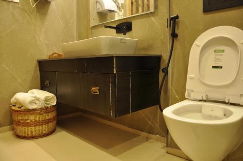 ein Badezimmer mit Toilette und einem Korb mit Handtüchern in der Unterkunft CEDARS Resorts - Doodhpathri Kashmir in Rengazabal