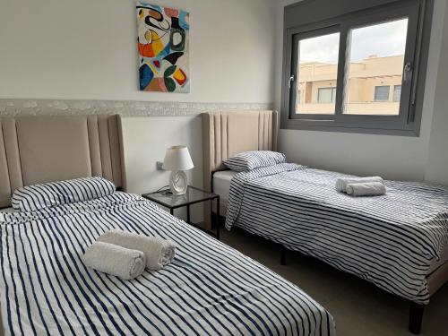 a bedroom with two beds with towels on them at Villa Amalia 54 in Torrevieja