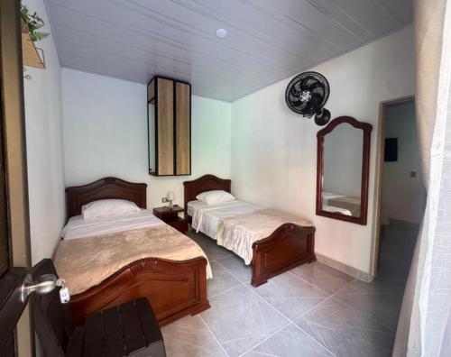 a bedroom with two beds and a mirror in it at Tierra Dulce - Casa Turística in Villeta