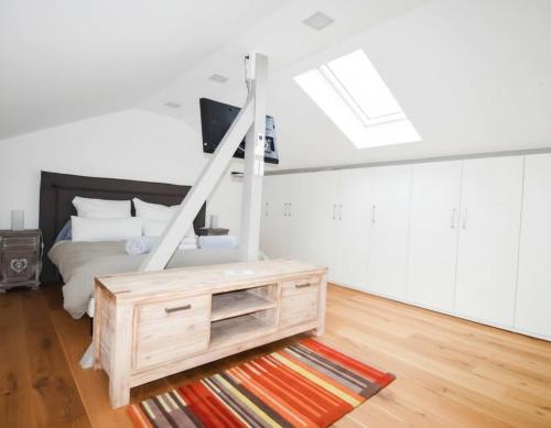 a white bedroom with a bed and a skylight at KeschtaLoft - Gîte classé 4 étoiles in Châtenois