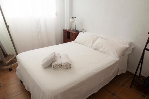 a bedroom with two towels on a white bed at Comfortable and Elegant Seafront Apartment in Faro de Cullera