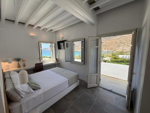 a bedroom with a bed and a large window at Myrto Hotel in Kamares
