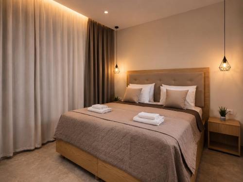 a bedroom with a large bed with two towels on it at Lion Exclusive Villa in Sarakinádhon