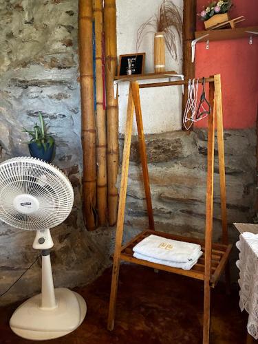 a room with a fan and a chair with a fan at Hostal Casa Horizonte in Taganga