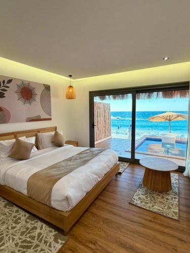 a bedroom with a bed and a view of the ocean at XU Sidi Abdel Rahman Resort & Spa in El Alamein