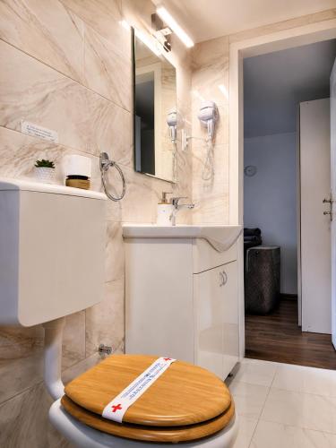 a bathroom with a sink and a wooden toilet in it at Romantic Mirka Apartment in Sremski Karlovci in Sremski Karlovci