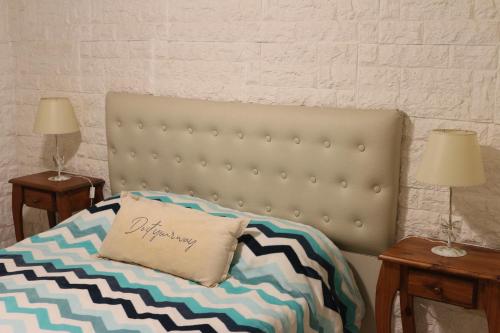 a bed with a pillow on it with two tables at MRU Colón aparts in Colón