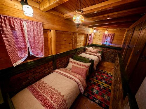 a group of four beds in a wooden room at Azure Pool Residence in Sarajevo