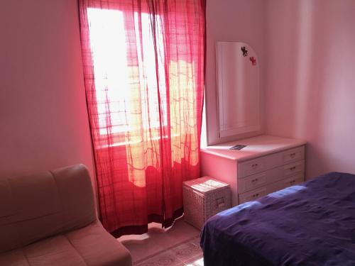 a bedroom with a bed and a dresser and a window at La Casa di Zoe in Uscio